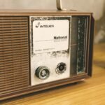 Close-up of a National Solid State vintage radio on a wooden table, featuring retro design and classic technology.